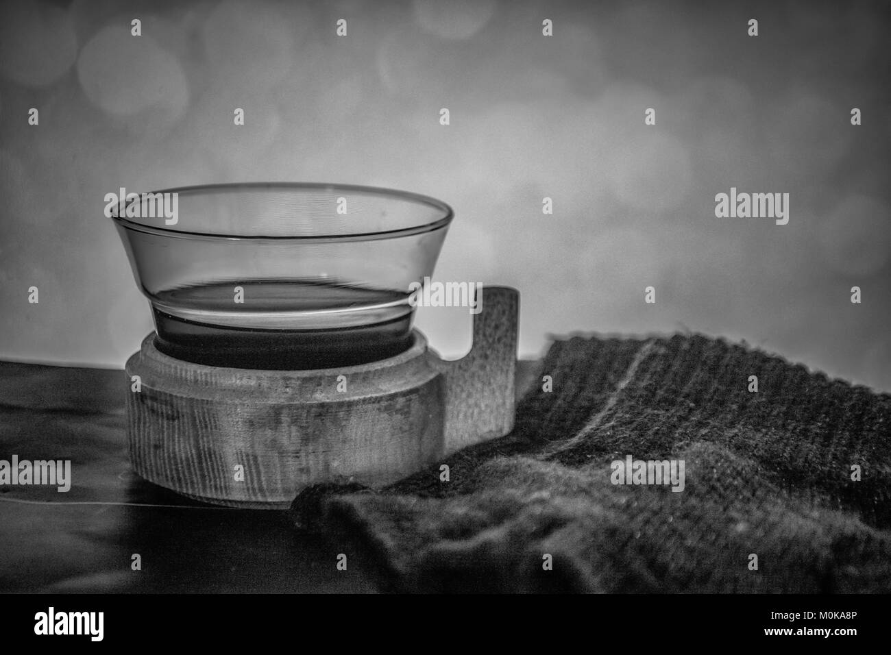 Foto in bianco e nero di un bicchiere di vin brulé e guanti Foto Stock