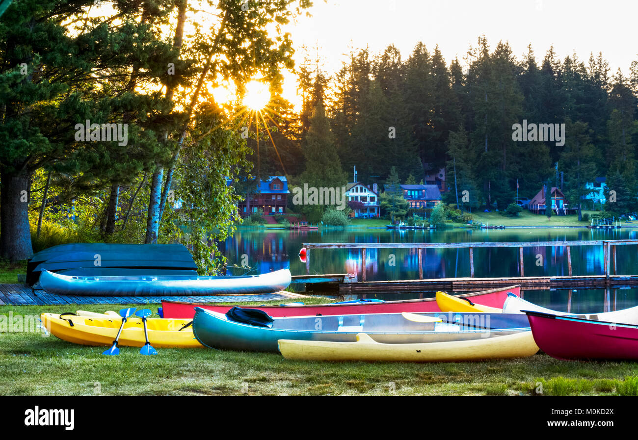 Una varietà di colorate canoe e kayak sulla riva di un accampamento di sunrise, Lakeside Camp; Whidbey Island, Washington, Stati Uniti d'America Foto Stock