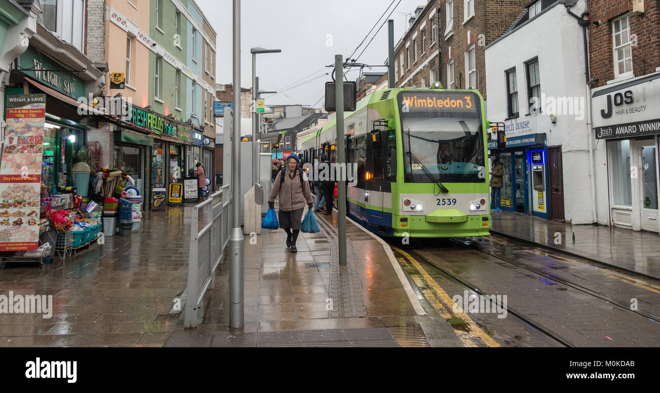 Una signora anziana veicoli pesanti sacchetti di plastica avendo avuto un tram su Croydon, a sud di Londra. Foto Stock