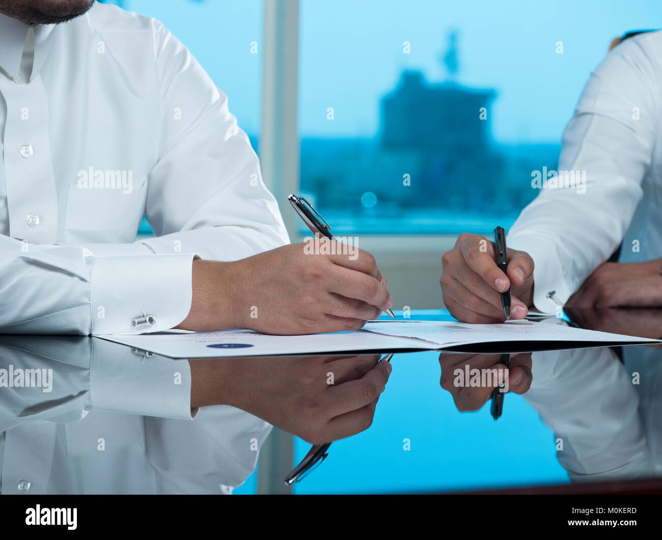 Due uomini di affari saudita Mani di firmare un documento, contratto o facendo una trattativa Foto Stock