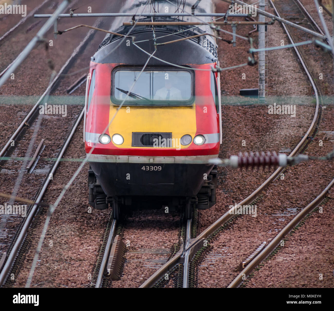 Vista del motore del treno Virgin in avvicinamento con cavi sospesi, East Lothian, Scozia, Regno Unito Foto Stock