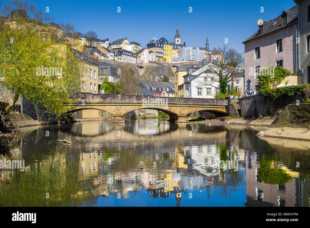 Visualizzazione classica del famoso centro storico della città di Lussemburgo che riflette in posizione idilliaca Alzette fiume su una bella giornata di sole con cielo azzurro in primavera Foto Stock