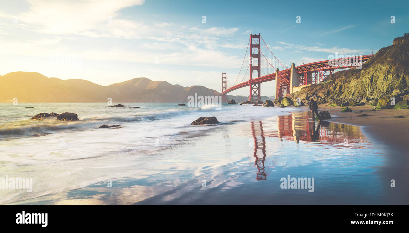 Classic vista panoramica del famoso Golden Gate Bridge visto da scenic Baker Beach in beautiful Golden luce della sera in una giornata di sole con cielo blu Foto Stock