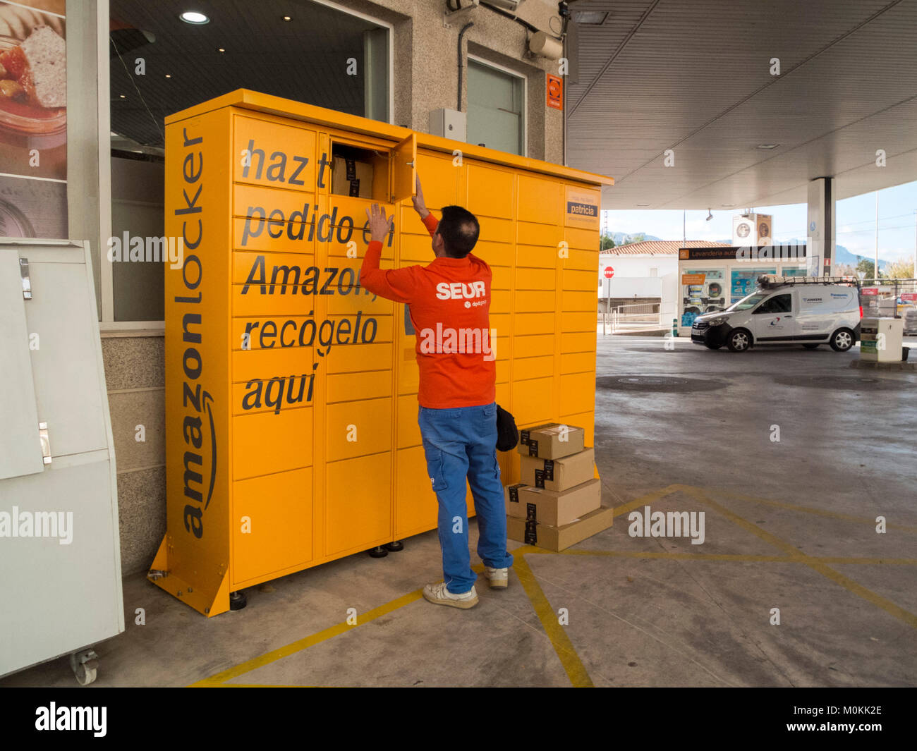 Il personale della Seur Logistics fornisce ad Amazon Locker i pacchetti presso la stazione di servizio di Altea, Alicante, Spagna Foto Stock