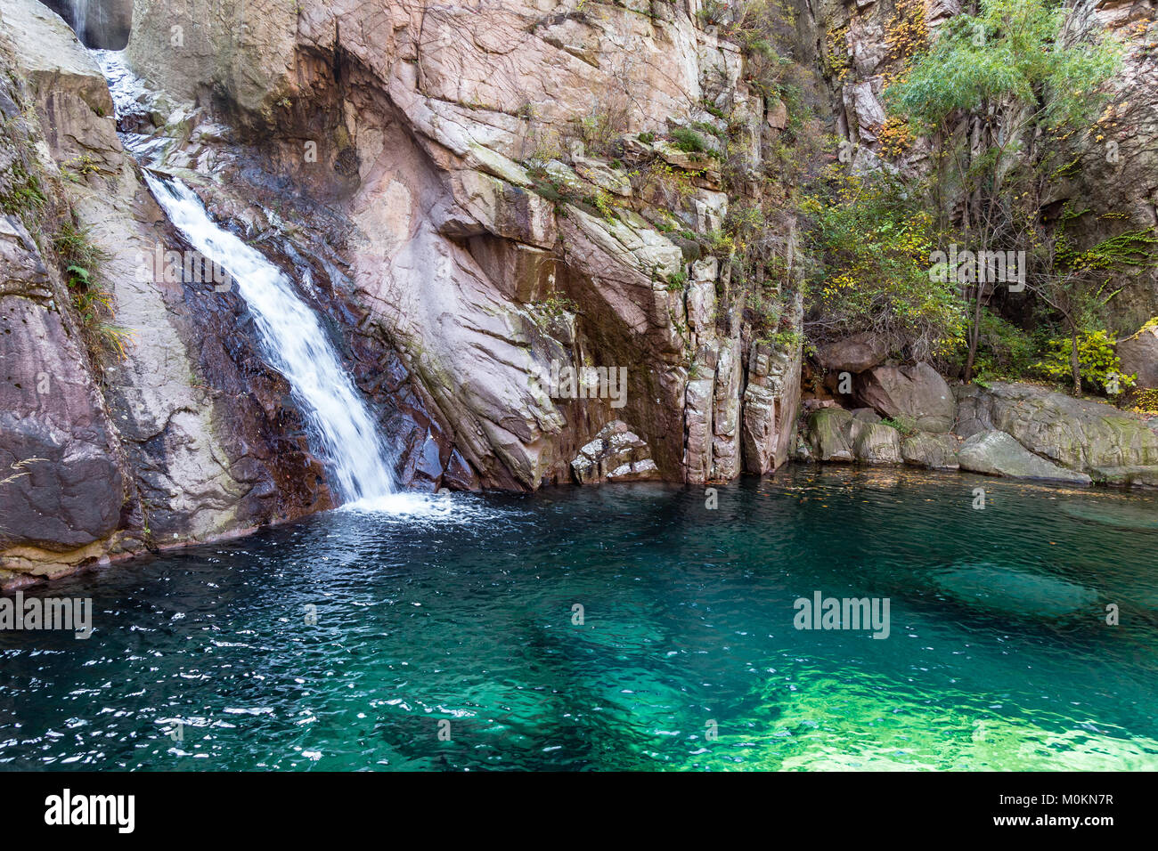 Cascata in bei Jiu Shui sentiero in autunno, Laoshan Mountain, Qingdao, Cina. Bei Jiu Shui è famosa per le numerose piscine di acqua cristallina e è Foto Stock