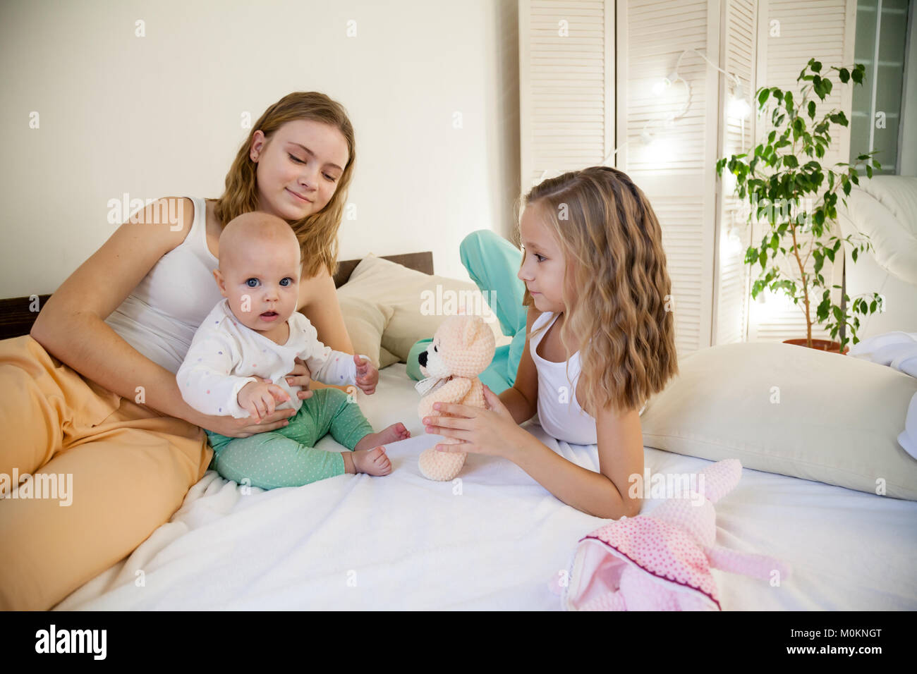 Le tre ragazze giocare sorelle al mattino in camera da letto Foto Stock