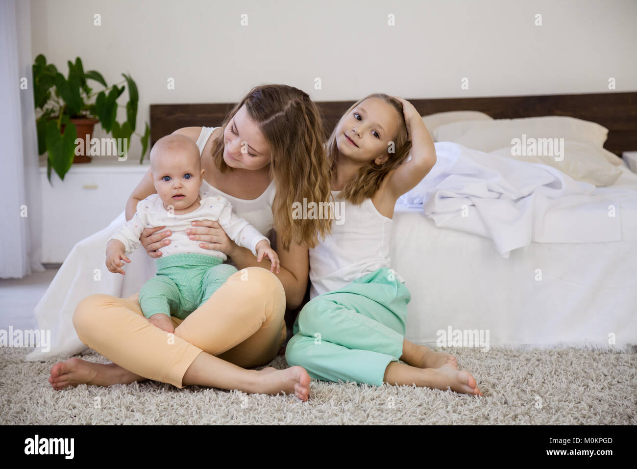 Le tre ragazze giocare sorelle al mattino in camera da letto Foto Stock