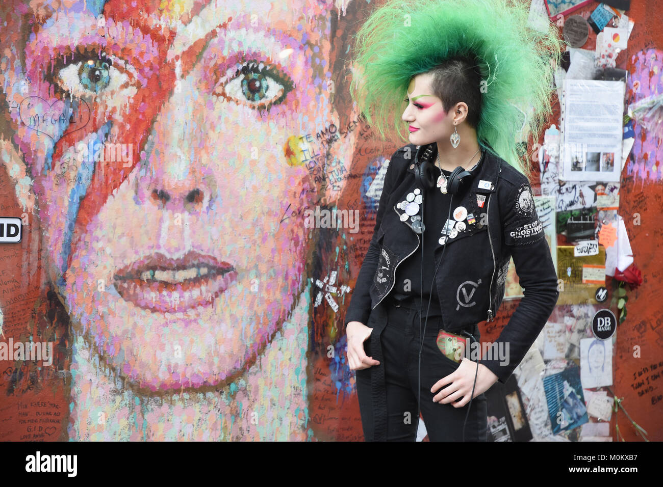 La signora punk si pone accanto al murale di Aladdin Sane a Brixton, nel secondo anniversario della morte di David Bowie il 10.01.2016, Brixton, London.UK Foto Stock