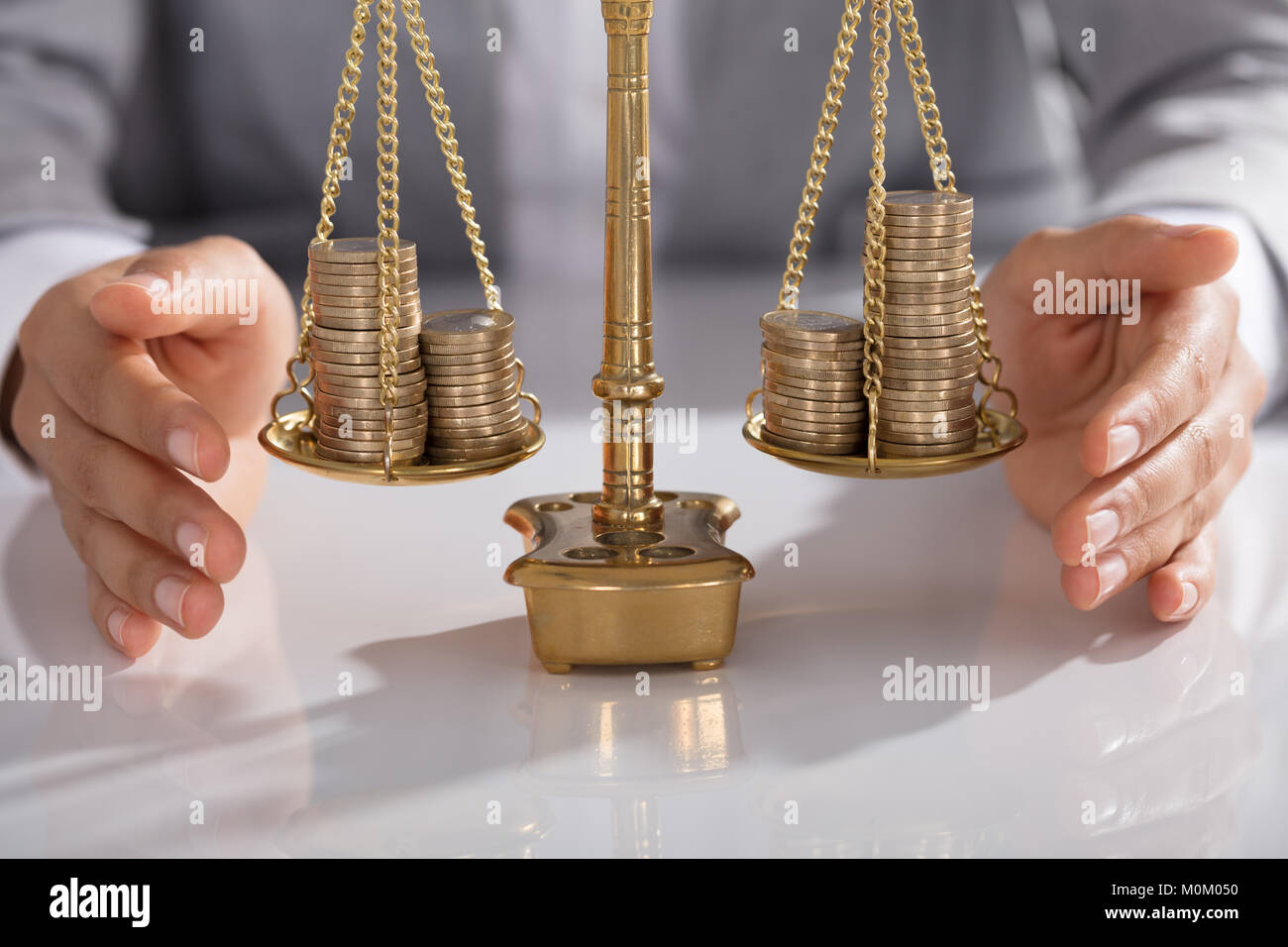 Close-up di commercianti la mano della giustizia di protezione scala con impilati di monete in ufficio Foto Stock