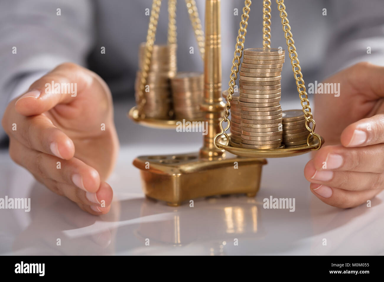 Close-up di commercianti la mano della giustizia di protezione scala con impilati di monete in ufficio Foto Stock