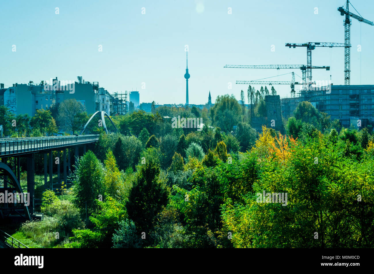 Berlino - braccio gru da cantiere e green panorama con la torre della televisione. Scena visto da di Prenzlauer Berg. Foto Stock