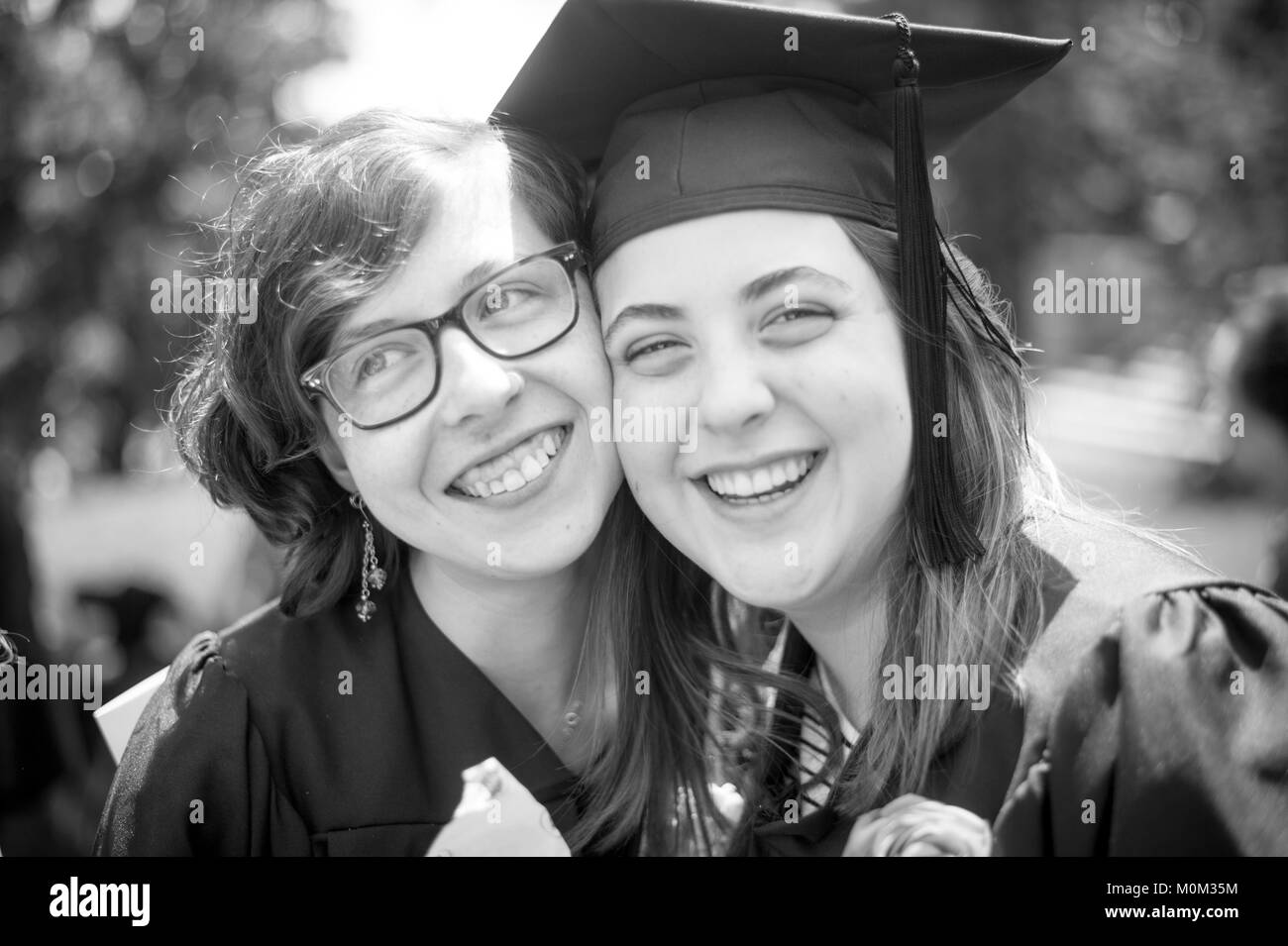 Due giovani donne laureati abbraccio e sorriso con uno un altro, Swarthmore, Pennsylvania Foto Stock
