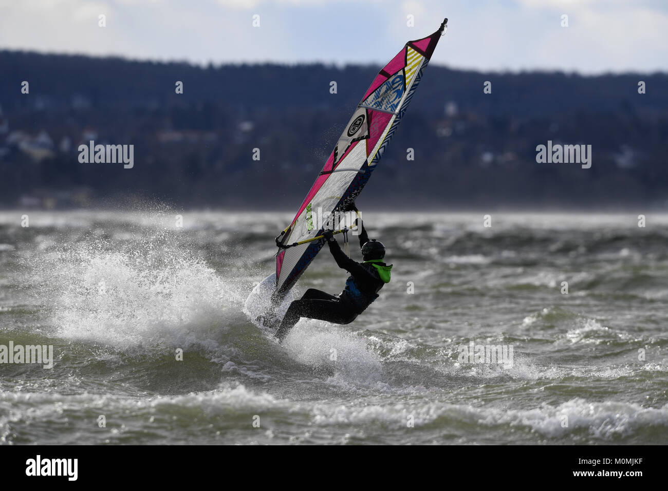 Herrsching, Germania. 18 gennaio, 2018. Durante i venti forti, un surfer Cavalca le onde forti causati dalla tempesta davanti "Friederike' sul lago Ammersee in Herrsching, Germania, 18 gennaio 2018. Credito: Felix Hörhager/dpa/Alamy Live News Foto Stock