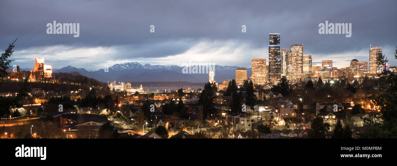 Una tempesta si muove al di sopra delle Montagne Olimpiche e del Puget Sound verso gli edifici e architettura di Seattle Washington Foto Stock