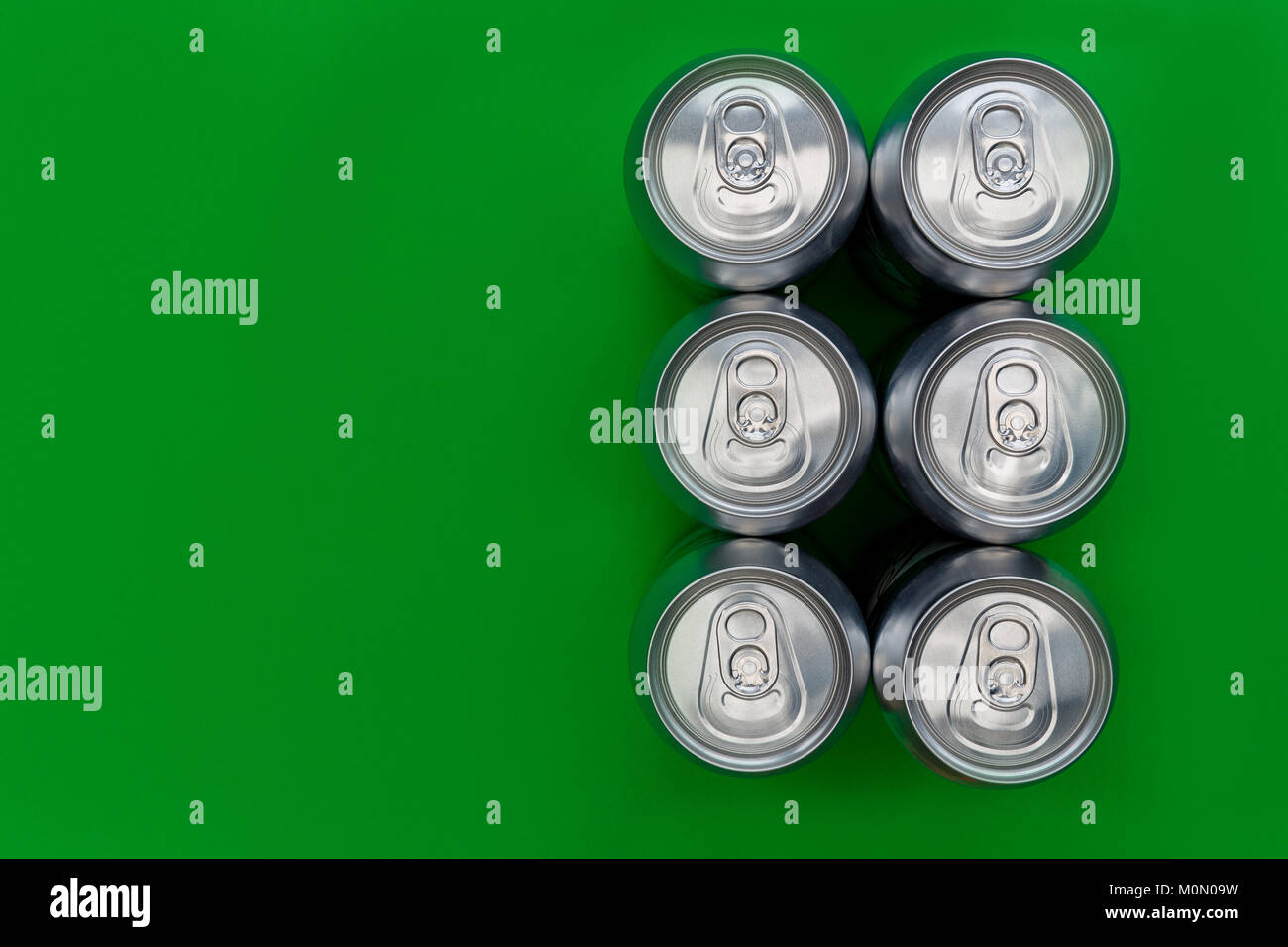 Argento metallico lattine overhead su sfondo verde Foto Stock