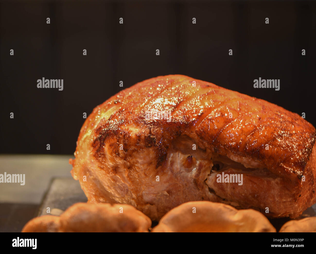 Chiudere il cibo fotografia immagine di una cotta e appoggio arrosto misto di carne di un gammon o di maiale con uno scuro su sfondo nero e lo spazio Foto Stock