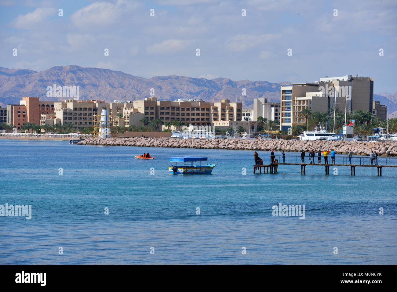 Aqaba Giordania - Marzo 14, 2014: la gente sul molo contro marina e nuovo hotel di North Beach. La città ha uno dei più alti tassi di crescita in Jorda Foto Stock