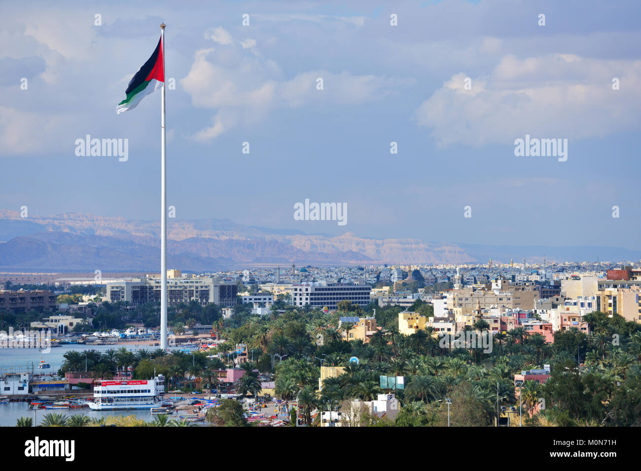 Aqaba Giordania - Marzo 14, 2014: Bandiera della Giordania sventolare sopra la città. Aqaba presenta uno dei tassi di crescita più alti in Giordania, con solo il 44% della sede, Foto Stock