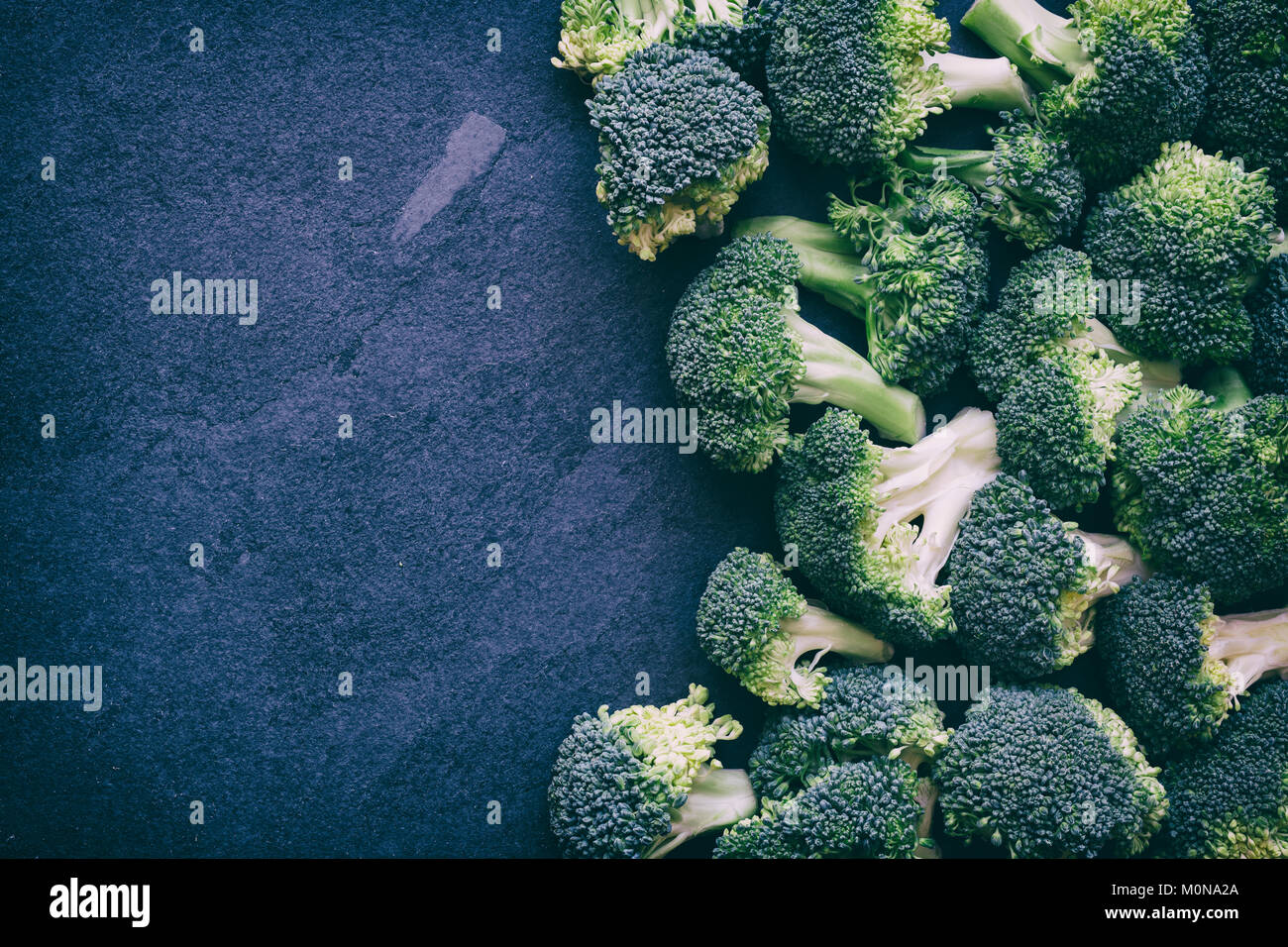 Brassica oleracea. Tagliare i broccoli su un sfondo di ardesia. Vintage filtro applicato Foto Stock