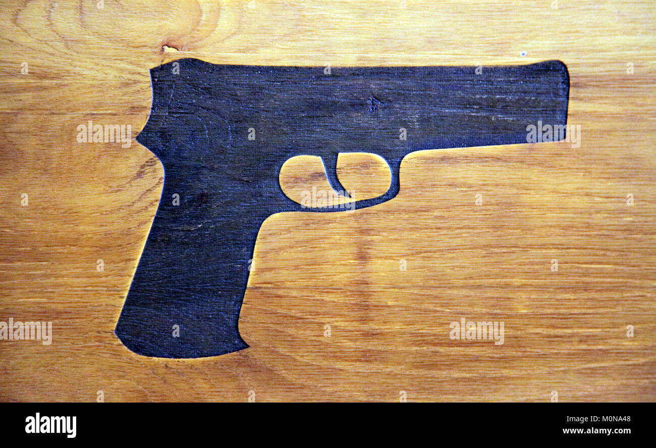 Pistola di nero forma stampata su pannello di legno Foto Stock