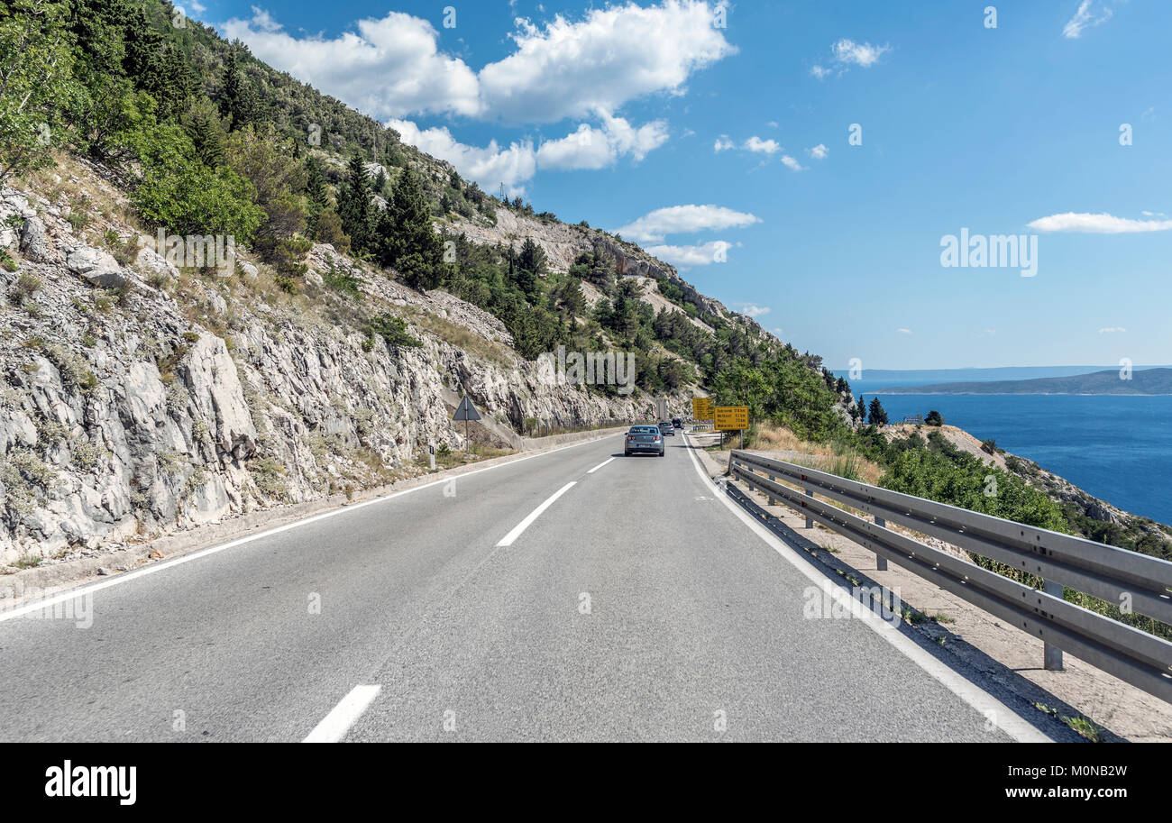 Un automobile strada lungo la costa del mare della zona balneare della Riviera di Makarska in Croazia. Foto Stock