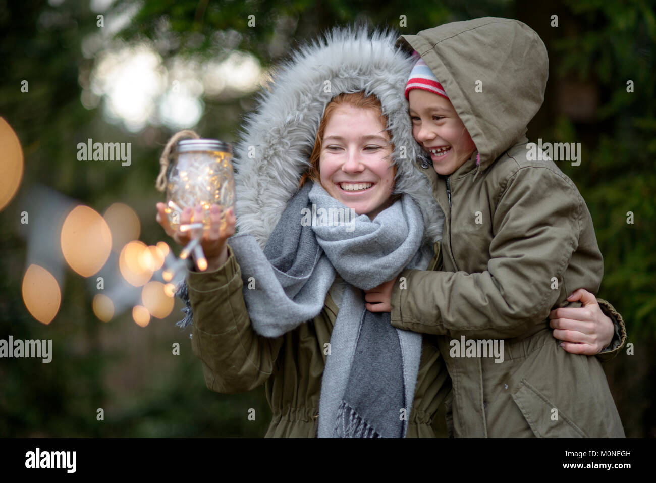 Mädchen mit funkelnden Lichterketten, Licht im Glas, im Winter, Oberbayern, Bayern, Deutschland Foto Stock