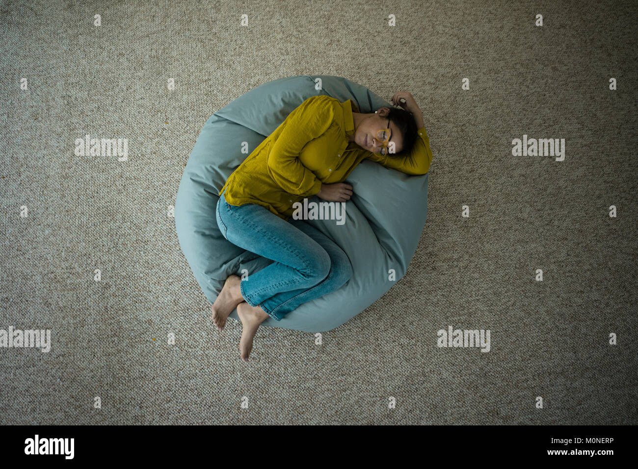 Donna che Dorme sul bean bag a casa, vista dall'alto Foto Stock