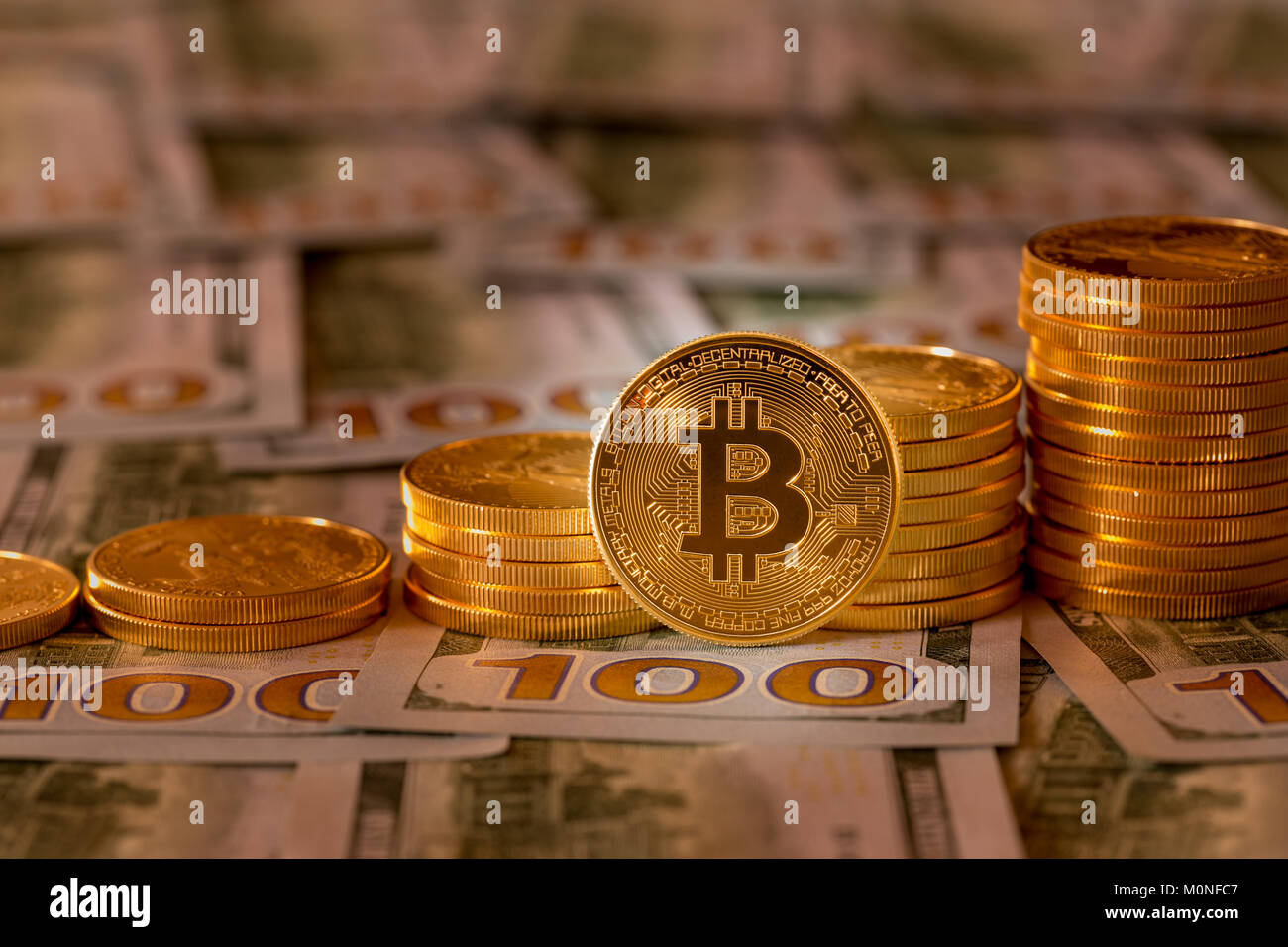 Bitcoins impilati sul nuovo design 100 fatture del dollaro Foto Stock