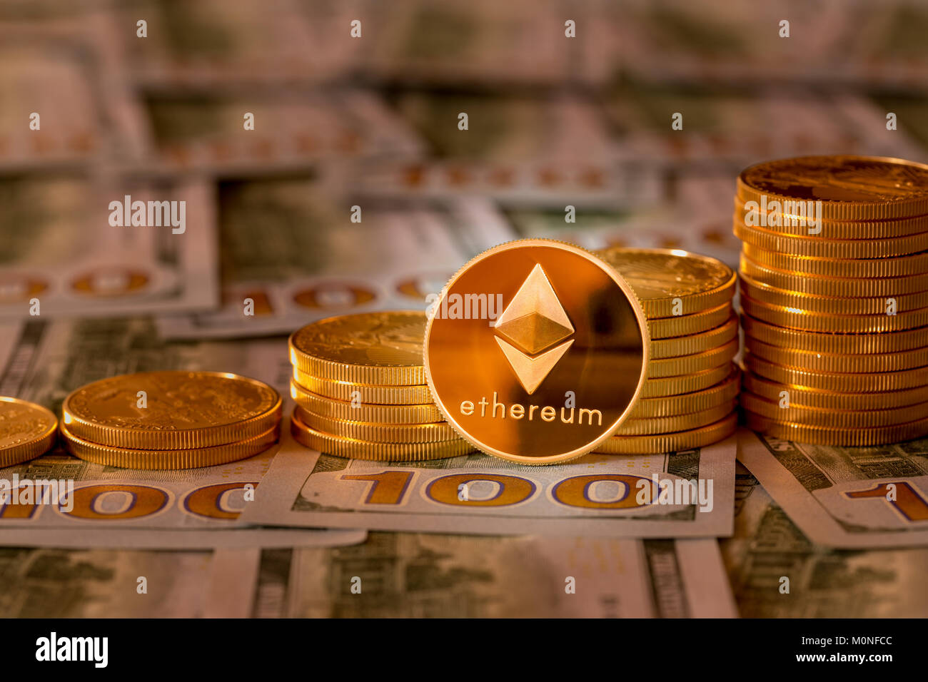 Bitcoins impilati sul nuovo design 100 fatture del dollaro Foto Stock