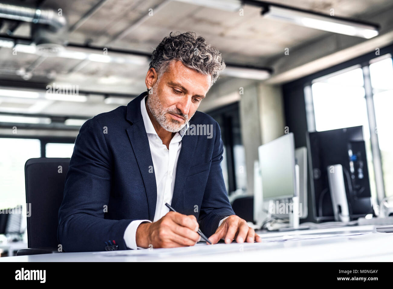 Coppia imprenditore iscritto alla scrivania in ufficio Foto Stock