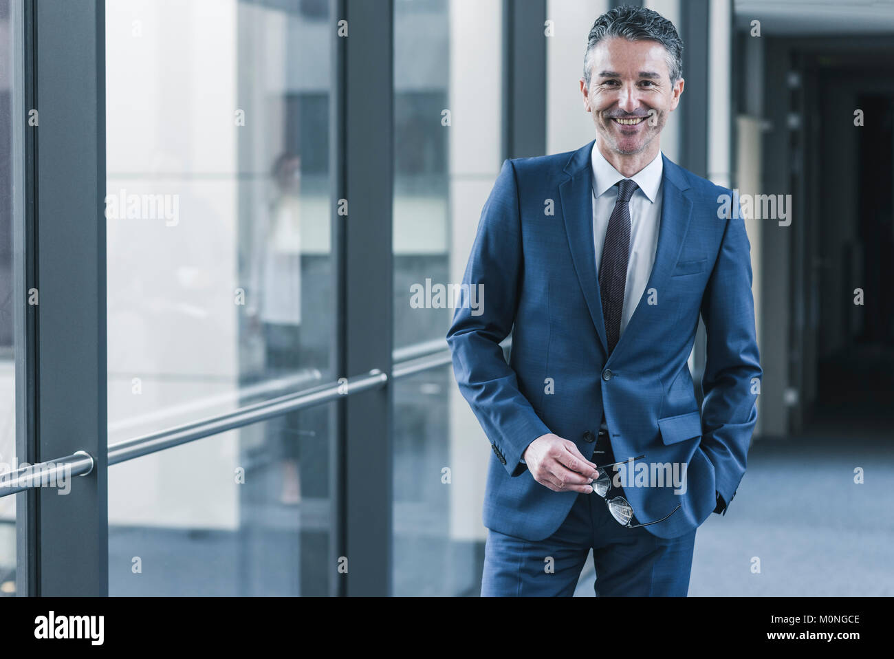 Ritratto di imprenditore sorridente sul pavimento per ufficio Foto Stock