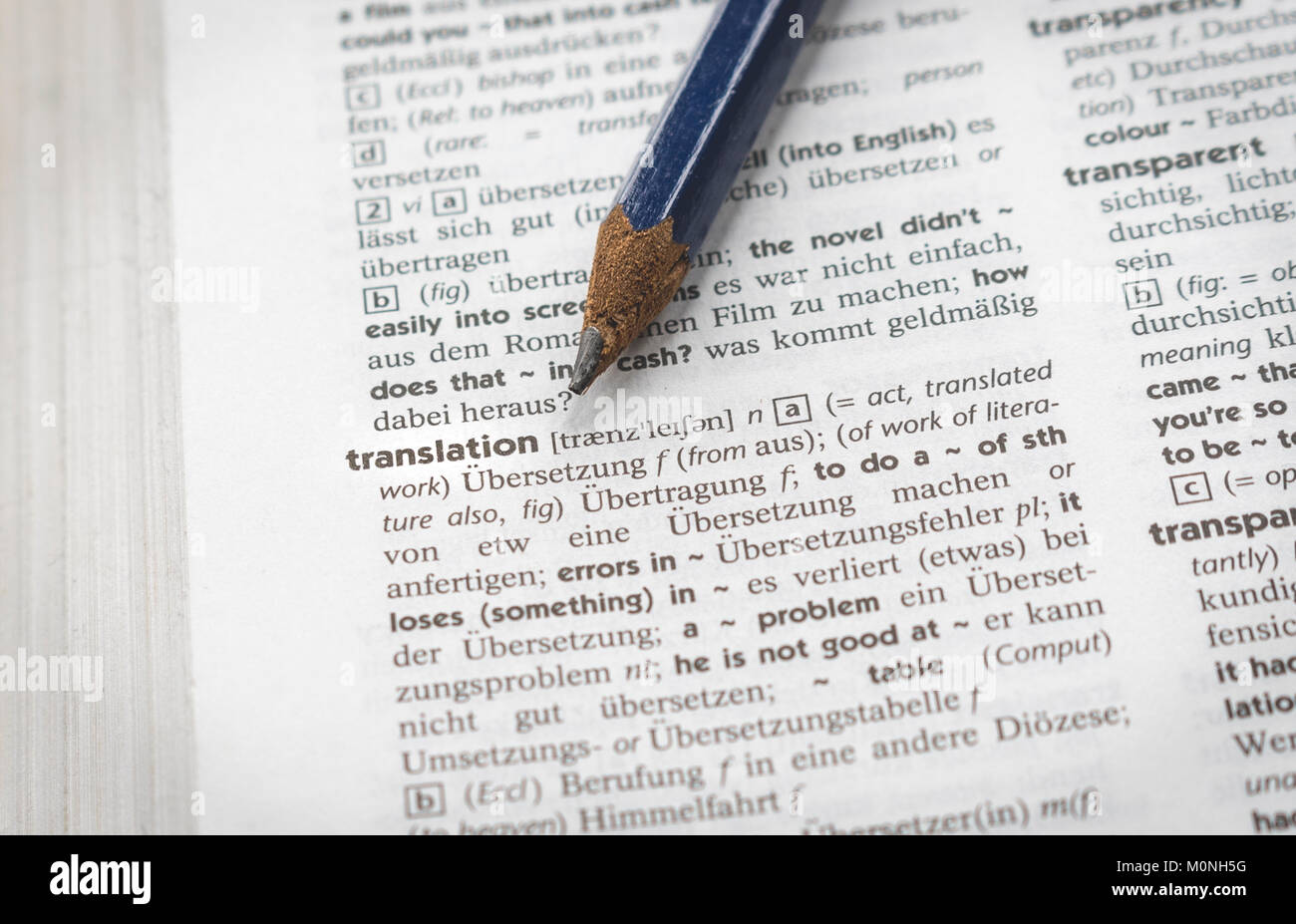 Concetto di traduzione, matita indicando la parola "traduzione" in un tedesco italiano dizionario Foto Stock