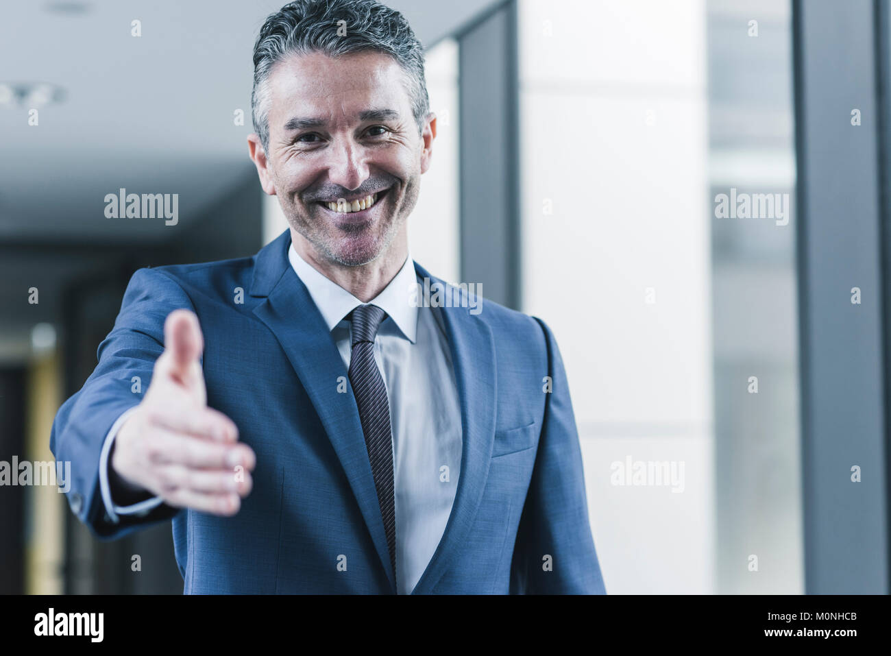 Ritratto di imprenditore sorridente circa per agitare le mani Foto Stock
