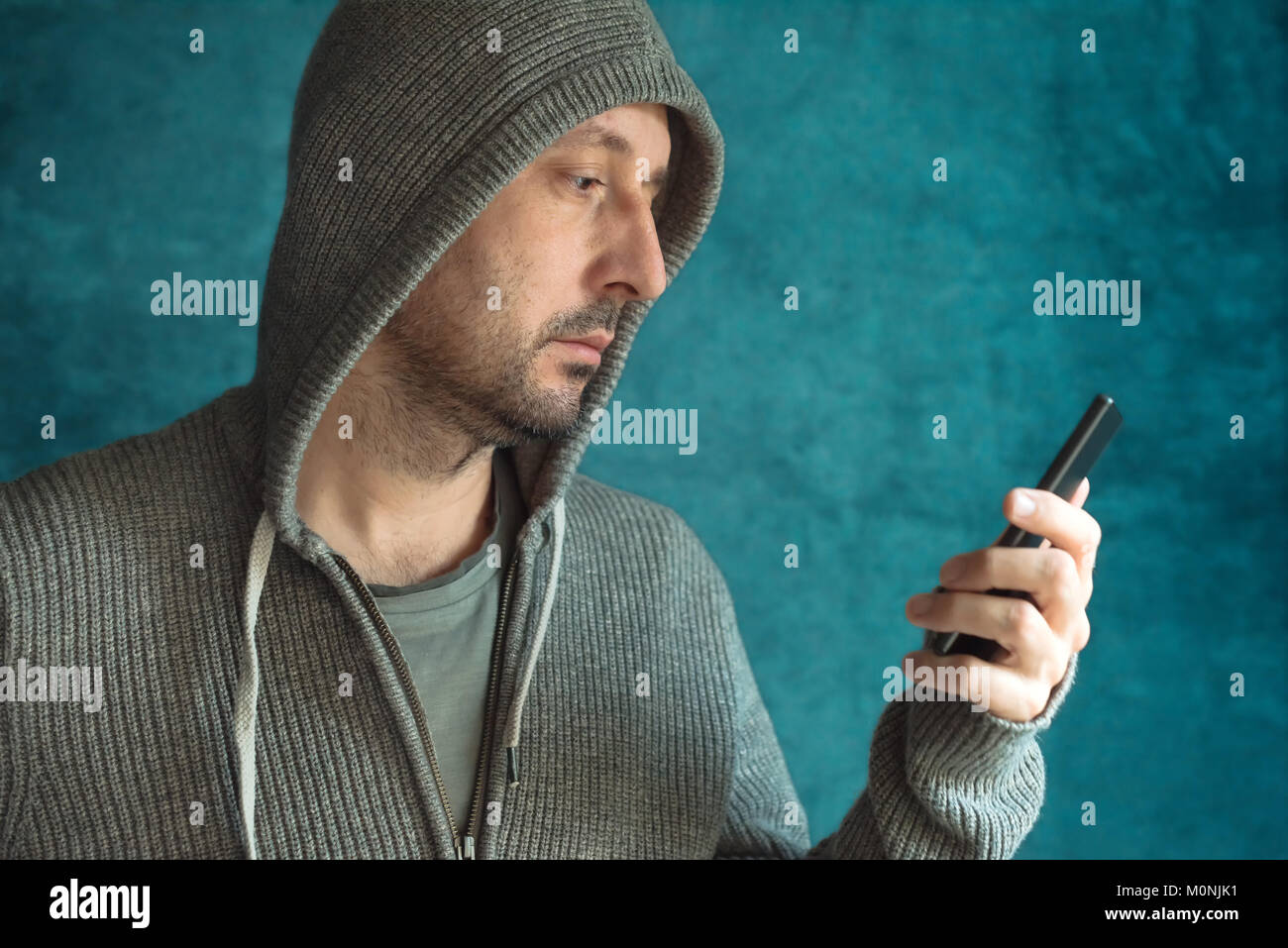 Uomo informale guardando il display del cellulare e app di lettura notifica o messaggio di testo SMS Foto Stock