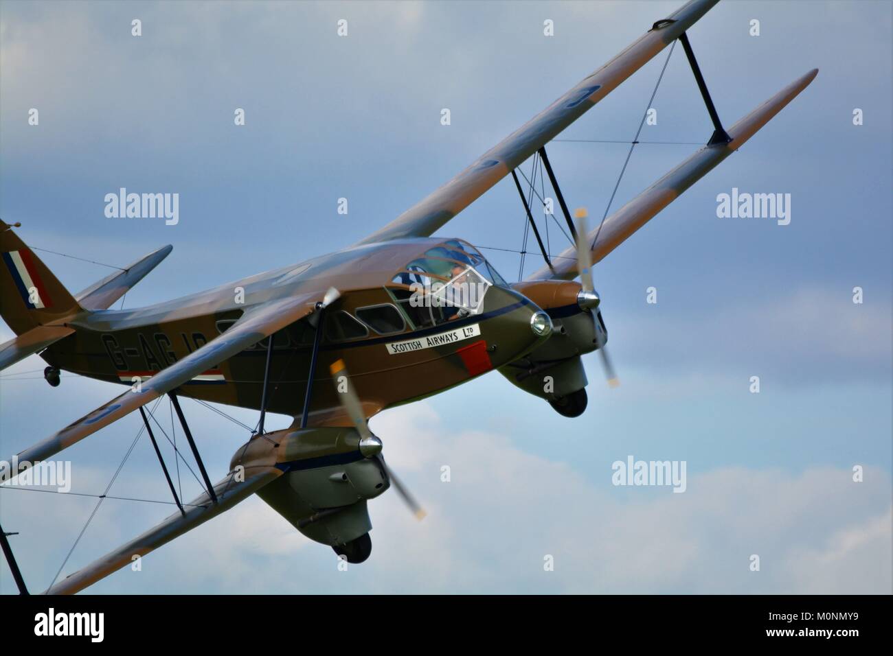 De Haviland Dragon rapide degli anni trenta aereo passeggeri G-AGJG in camuffamento schema di verniciatura in airshow Shuttleworth. Foto Stock