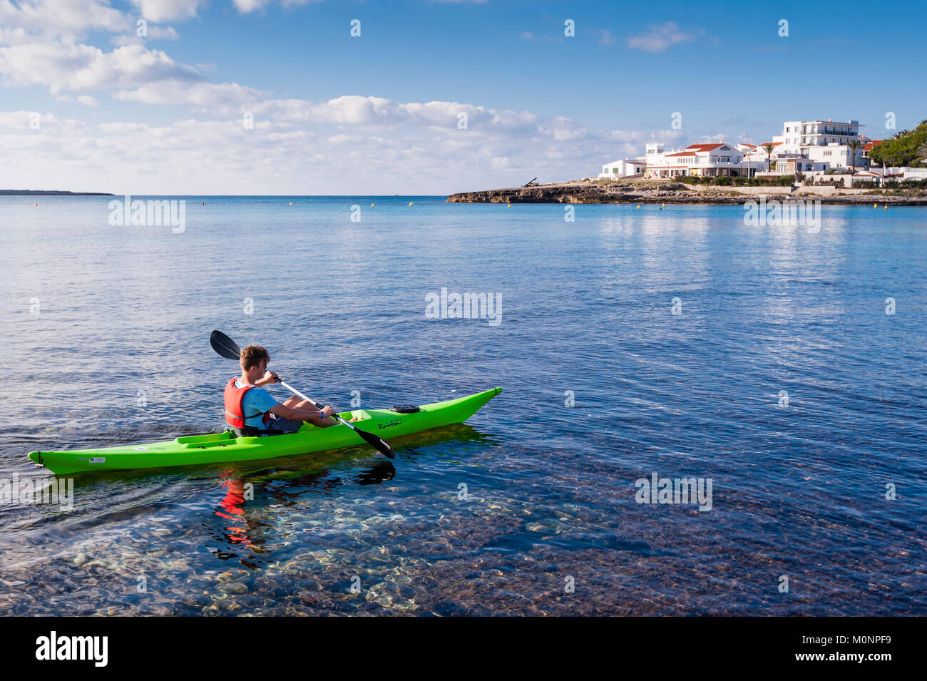 Un ragazzo adolescente in un kayak a Punta Prima , Minorca , Isole Baleari , Spagna Foto Stock