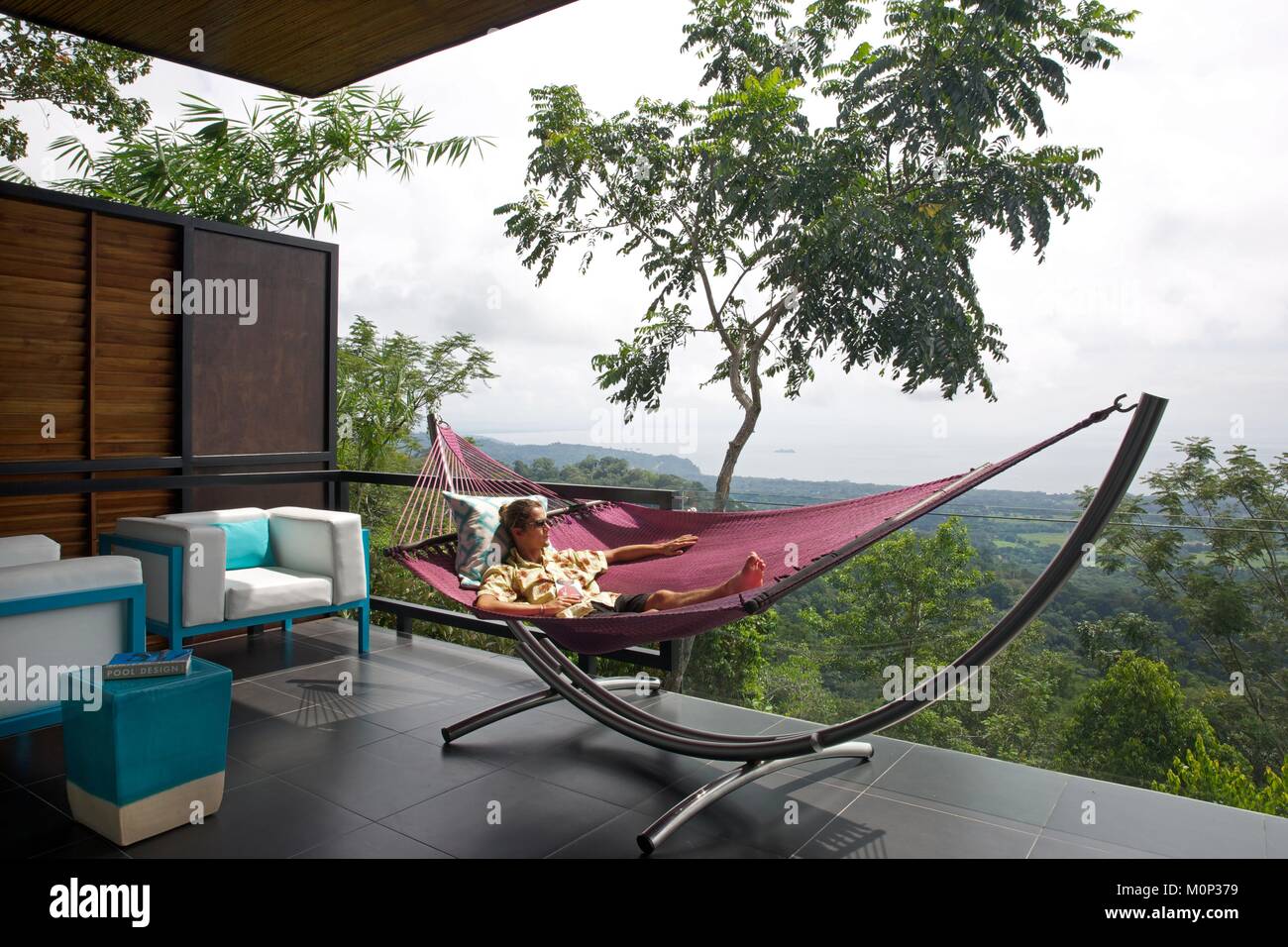 Costa Rica,osa peninsula,l uomo nella sua amaca in terrazza di un contemporaneo design suite nell'ecolodge Kura ville design,nel mezzo della foresta Foto Stock