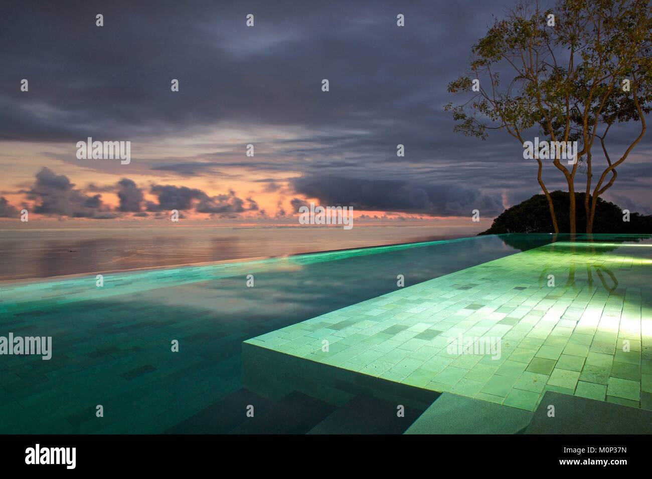 Costa Rica,osa peninsula,struttura riflettente sulla piscina dell'ecolodge Kura ville design illuminato al calar della sera,l'oceano di fronte Foto Stock