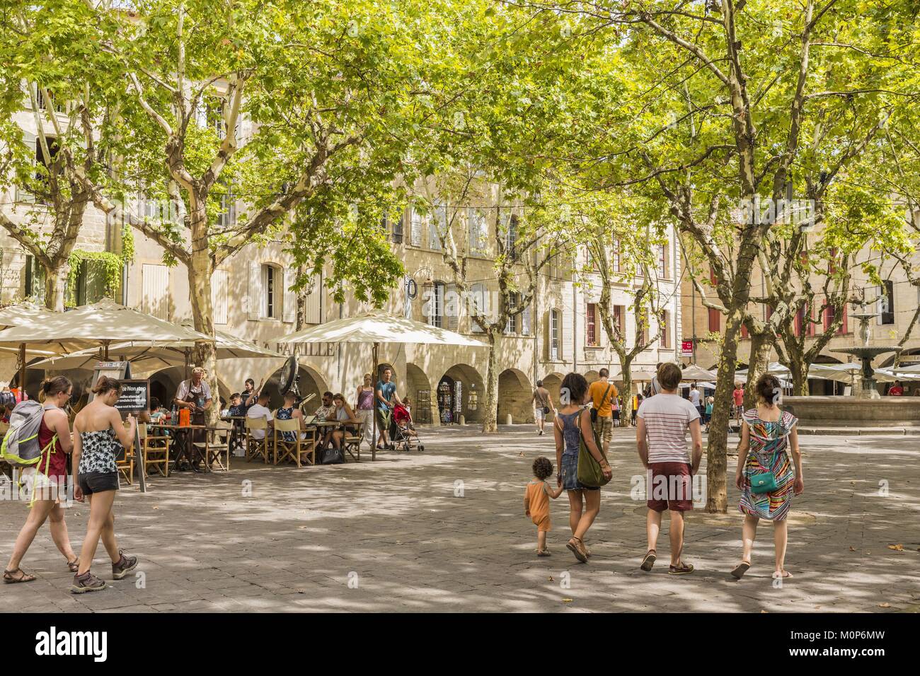 Francia,Gard,Pays d'Uzege,Uzes,la Place aux Herbes circondato da case porticate e i suoi caffè all'aperto Foto Stock