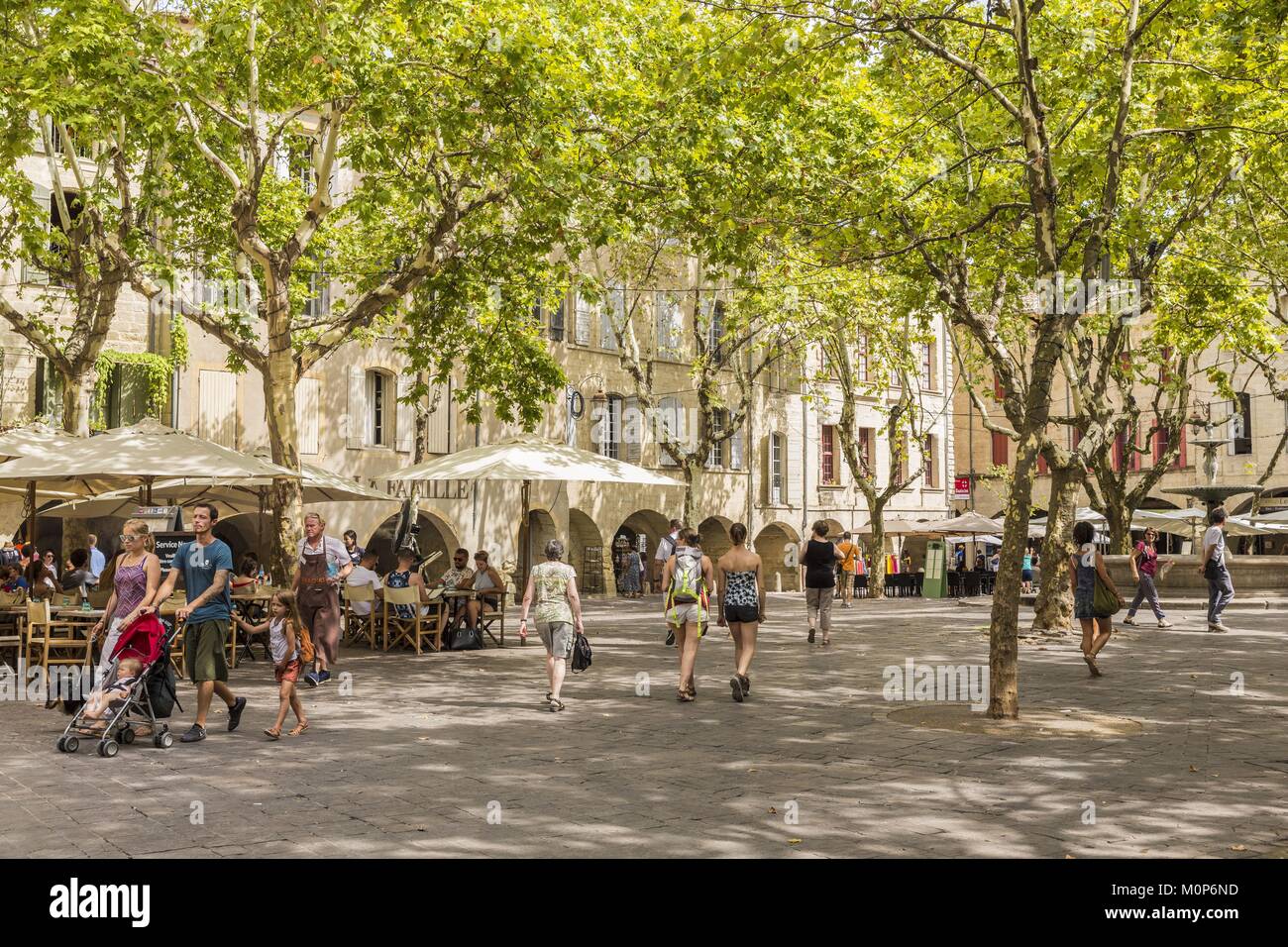 Francia,Gard,Pays d'Uzege,Uzes,la Place aux Herbes circondato da case porticate e i suoi caffè all'aperto Foto Stock