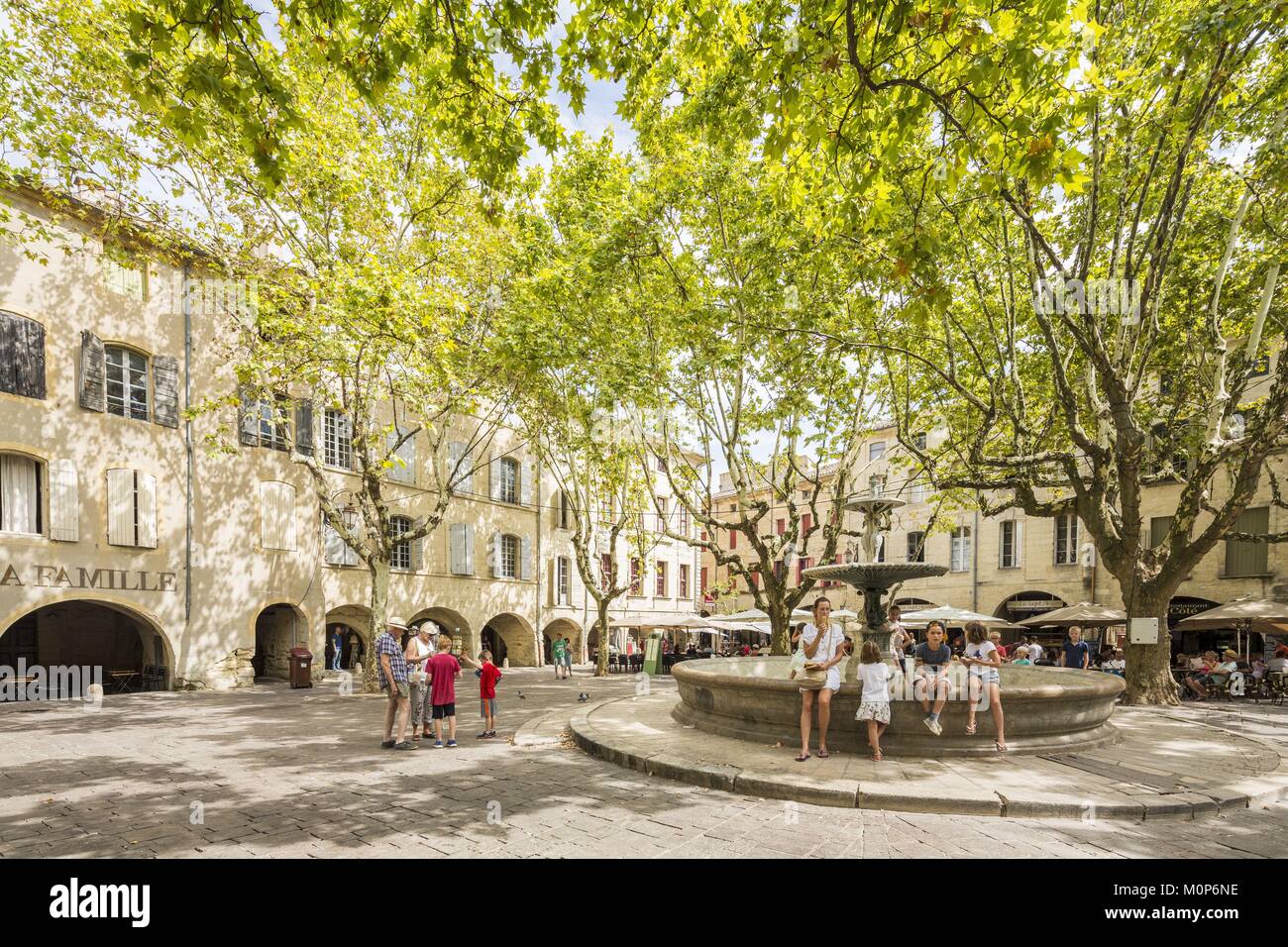 Francia,Gard,Pays d'Uzege,Uzes,la Place aux Herbes circondato da case porticate e i suoi caffè all'aperto Foto Stock