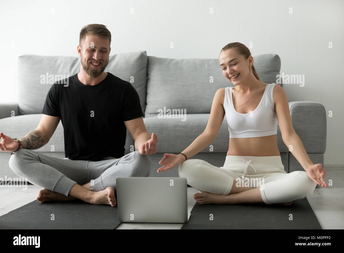 Sorridente giovane imparare esercizi yoga di guardare video sul computer portatile Foto Stock