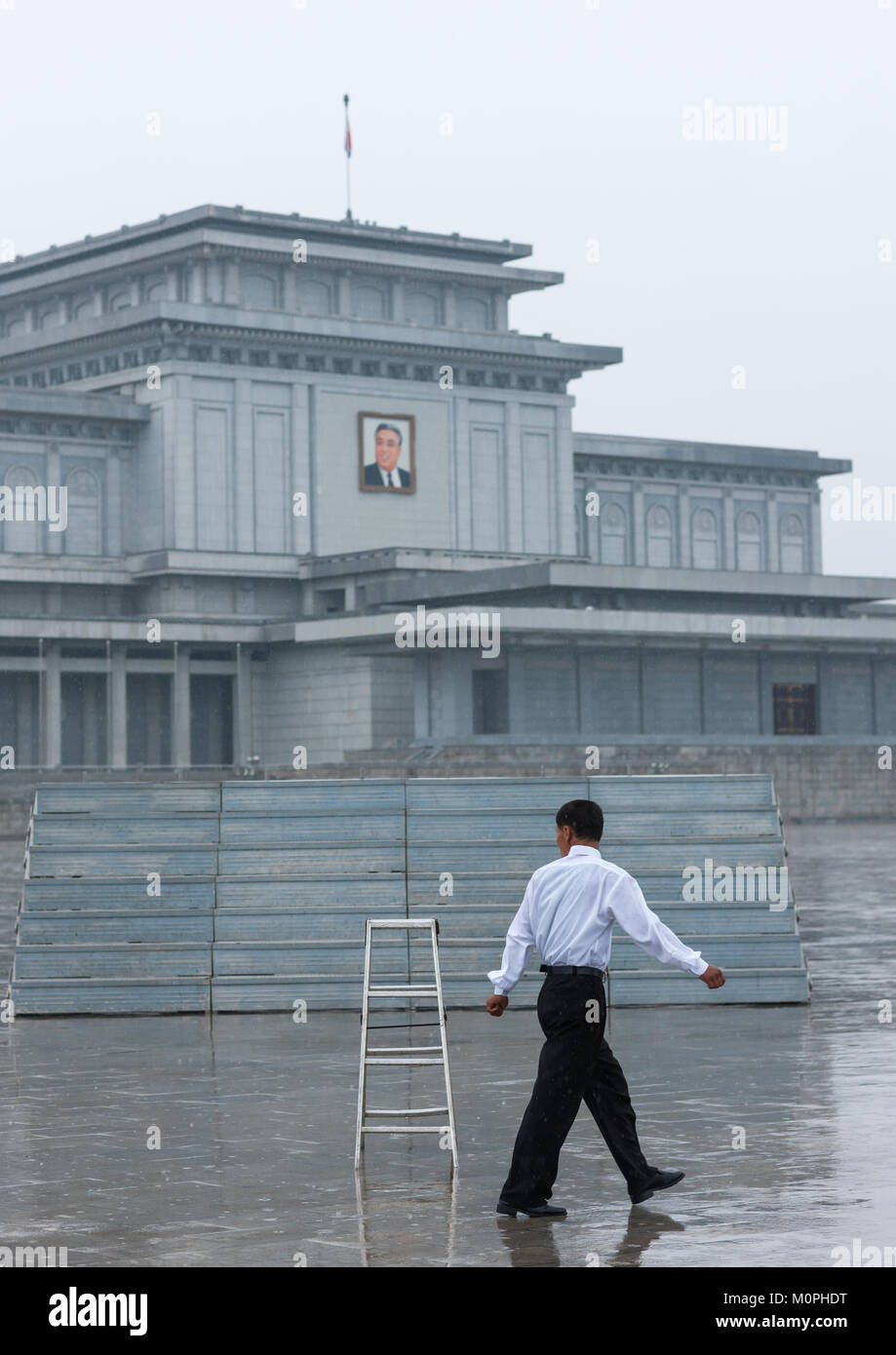 Corea del Nord uomo sotto la pioggia in Kumsusan memorial palace, Provincia di Pyongan, Pyongyang, Corea del Nord Foto Stock