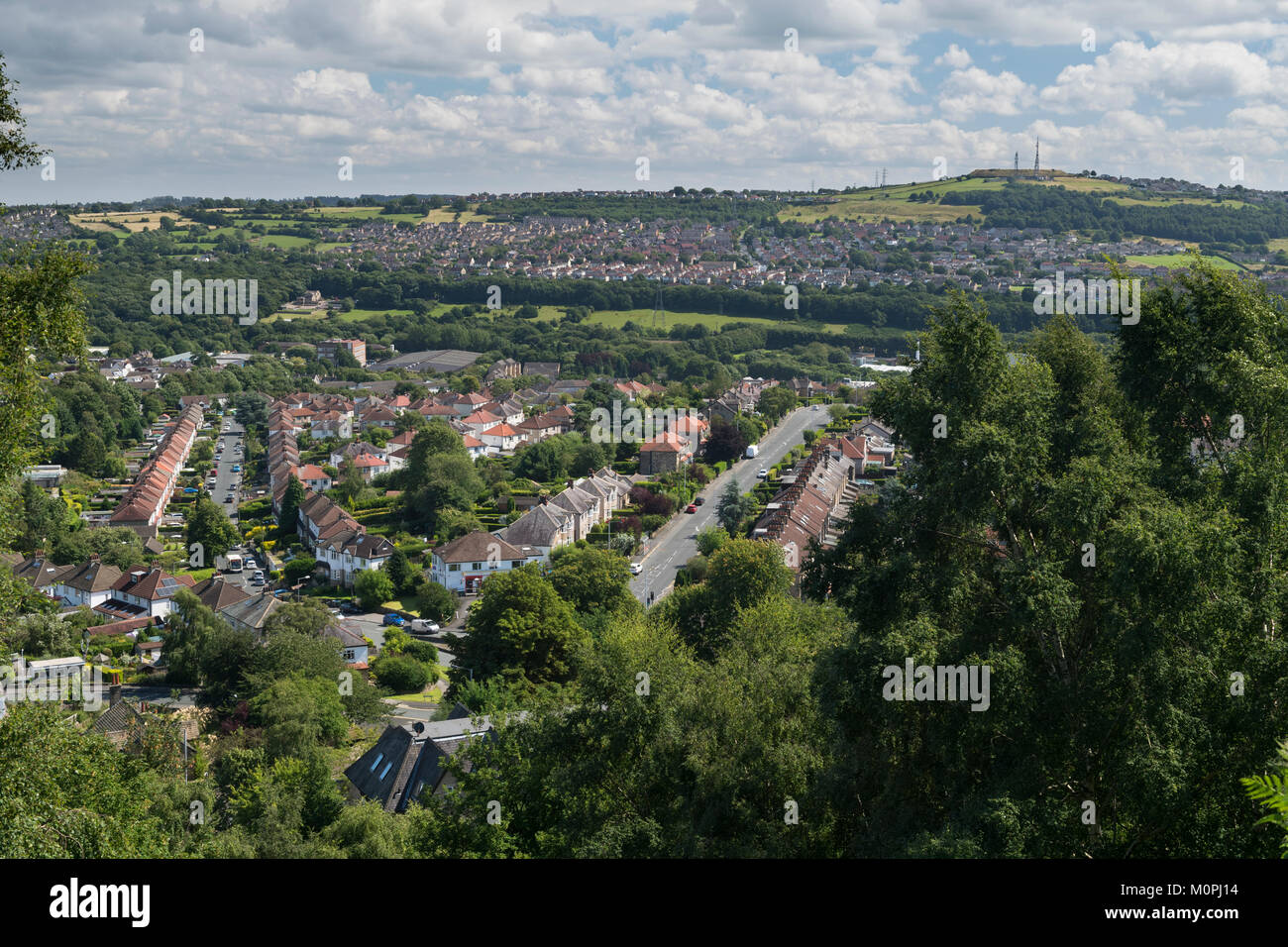 Panoramica scena urbana - Baildon town (in primo piano suburban semi-case unifamiliari) & zona residenziale di Bradford sulla collina al di là - Yorkshire, Inghilterra, Regno Unito Foto Stock