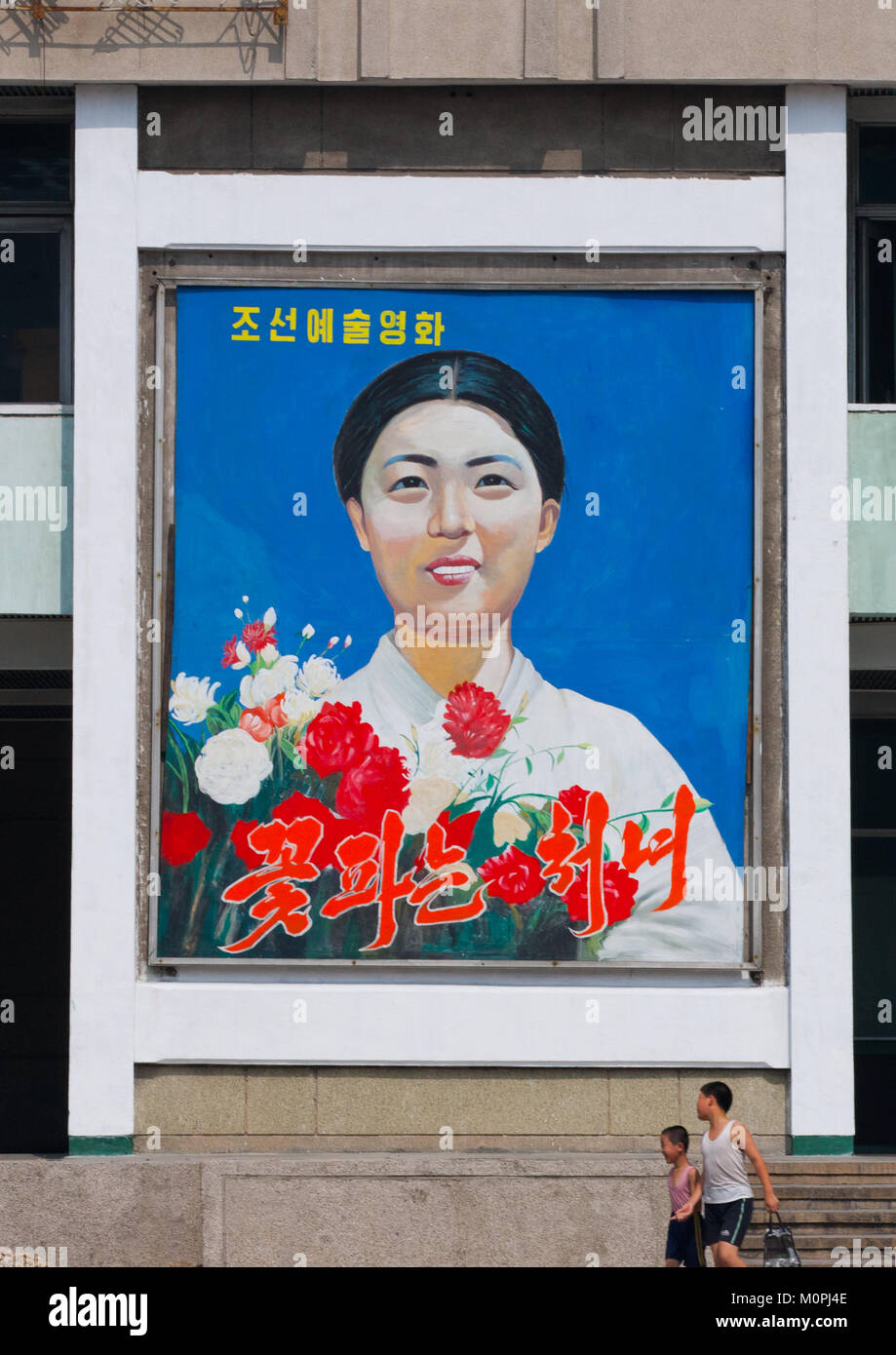 Il fiore ragazza nord coreano poster del filmato in strada, Provincia di Pyongan, Pyongyang, Corea del Nord Foto Stock