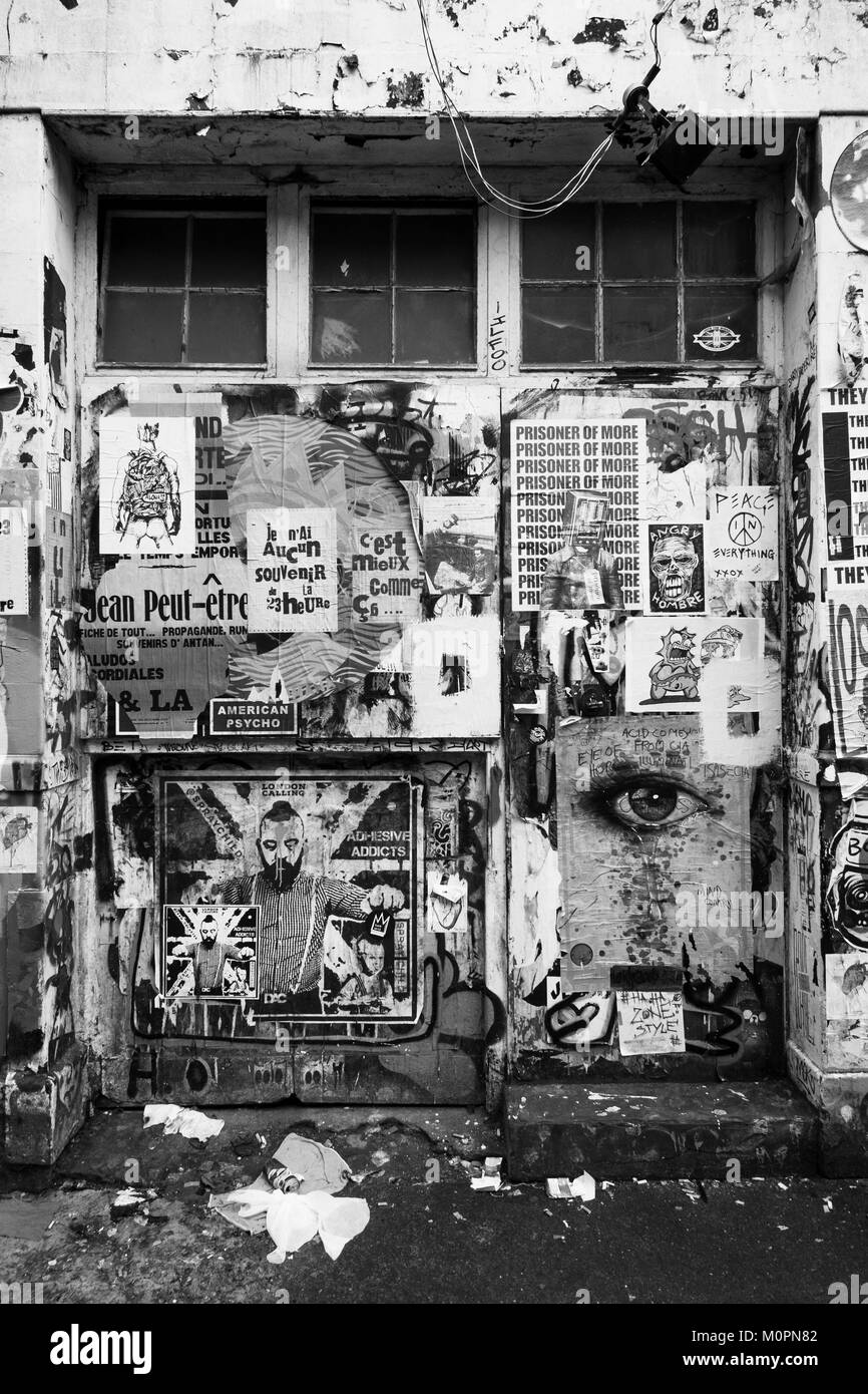 Londra in bianco e nero fotografia urbani: parete ricoperta con poster, Brick Lane, a est di Londra. Foto Stock