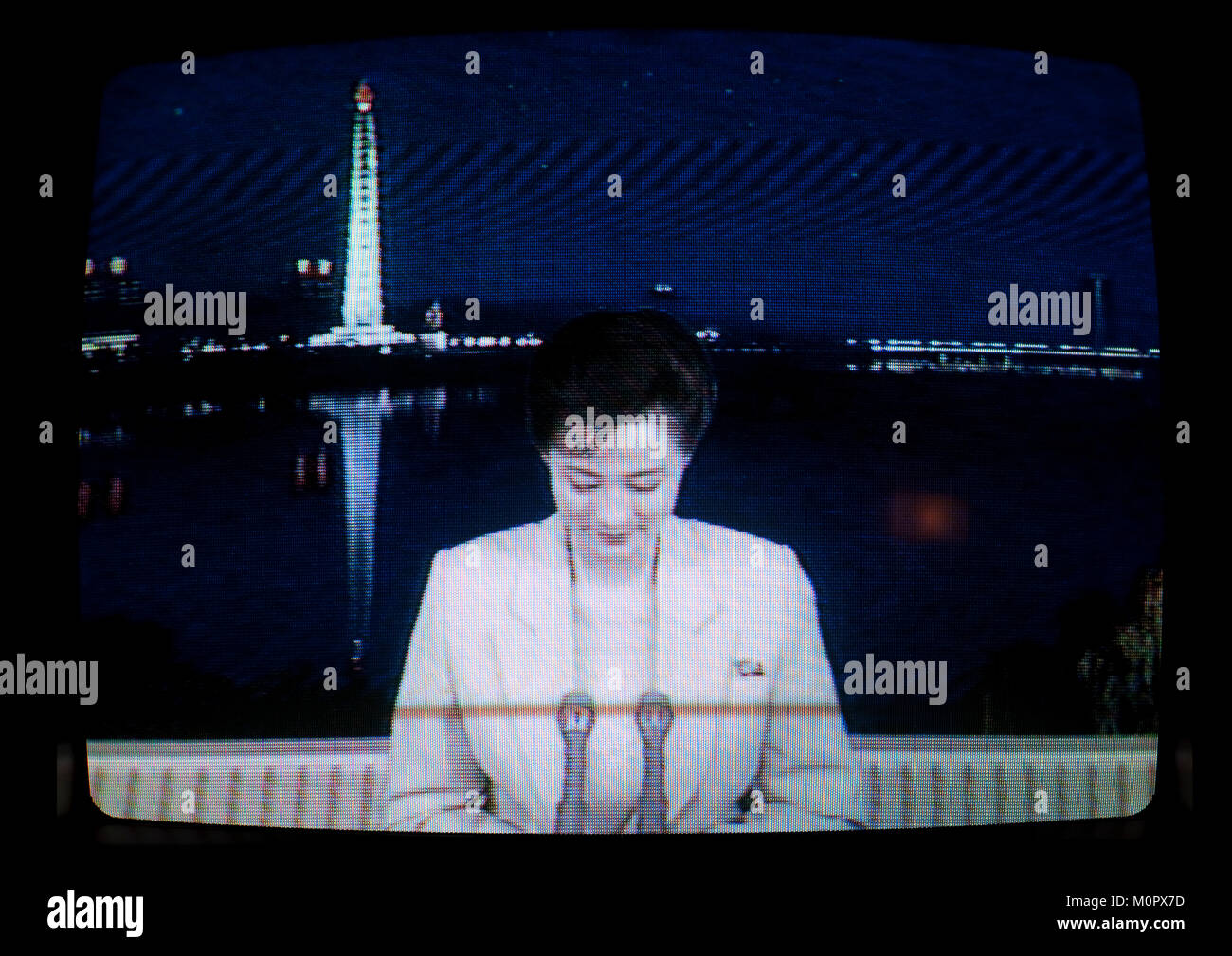 Corea del Nord notizie televisive presenter con la torre Juche in background, Provincia di Pyongan, Pyongyang, Corea del Nord Foto Stock