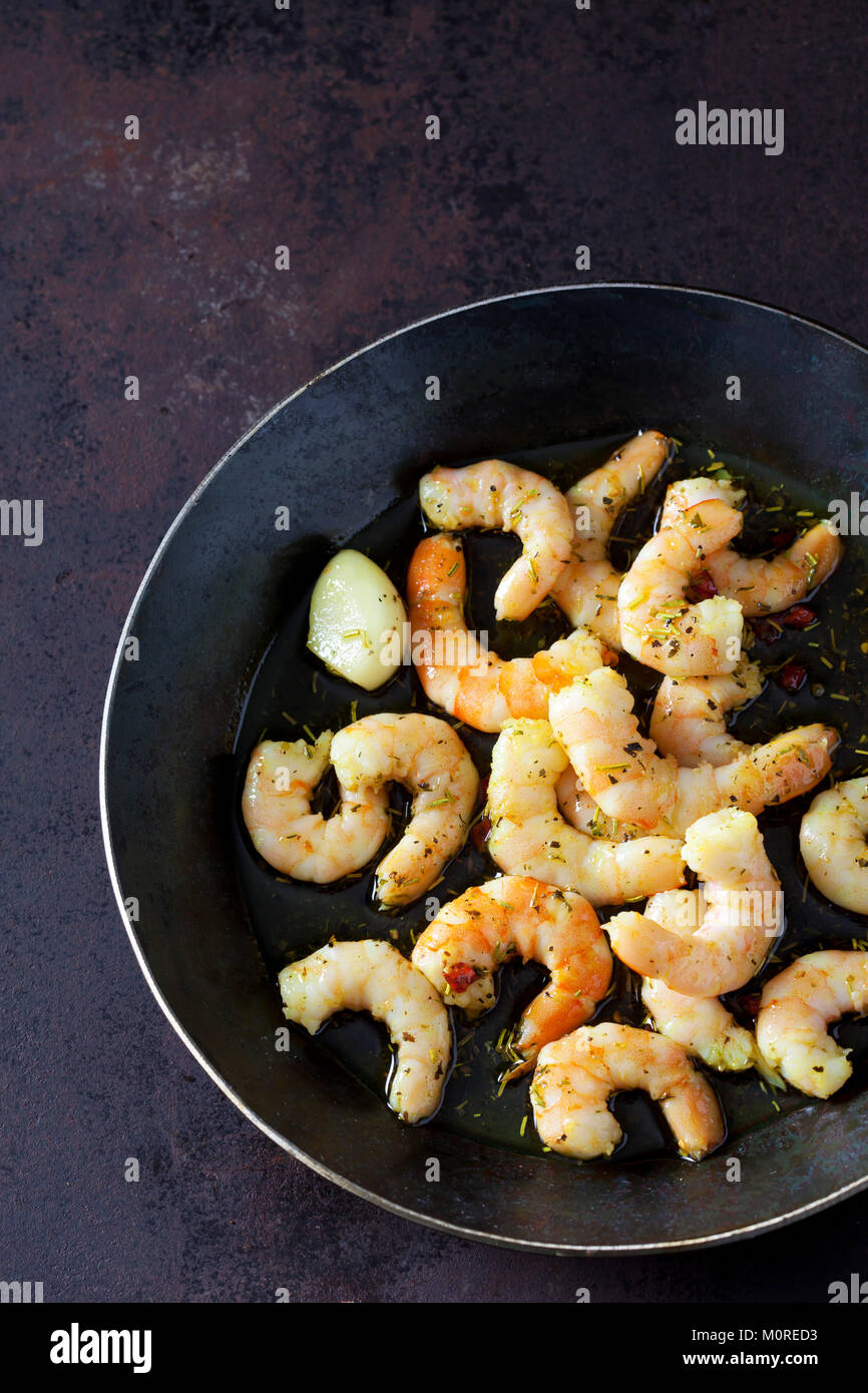 La Frittura di gamberetti in padella con olio, aglio ed erbe aromatiche Foto Stock