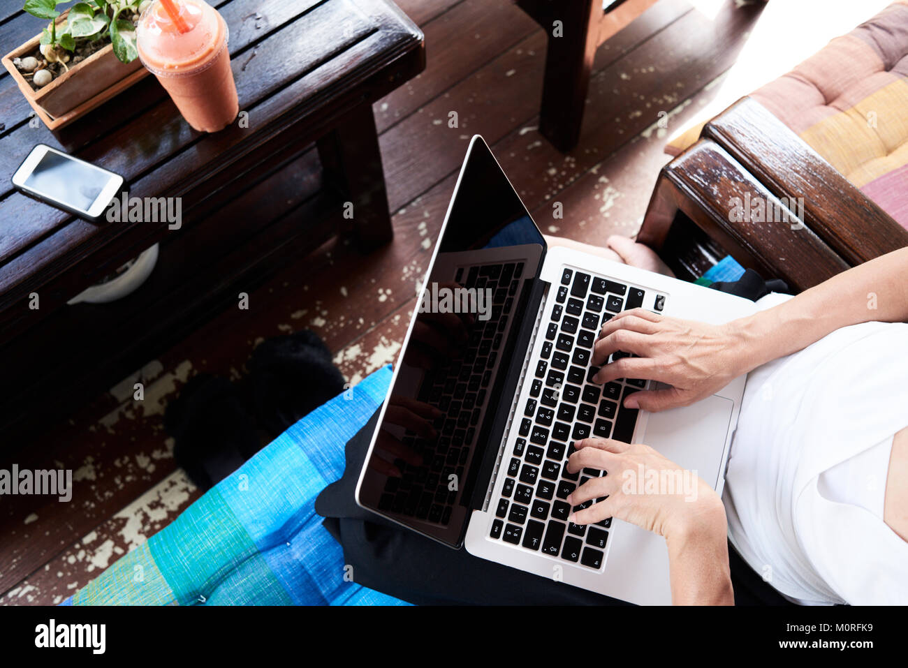 Da sopra vista di un senior business donna lavora con il suo portatile, avente un frullato. Foto Stock