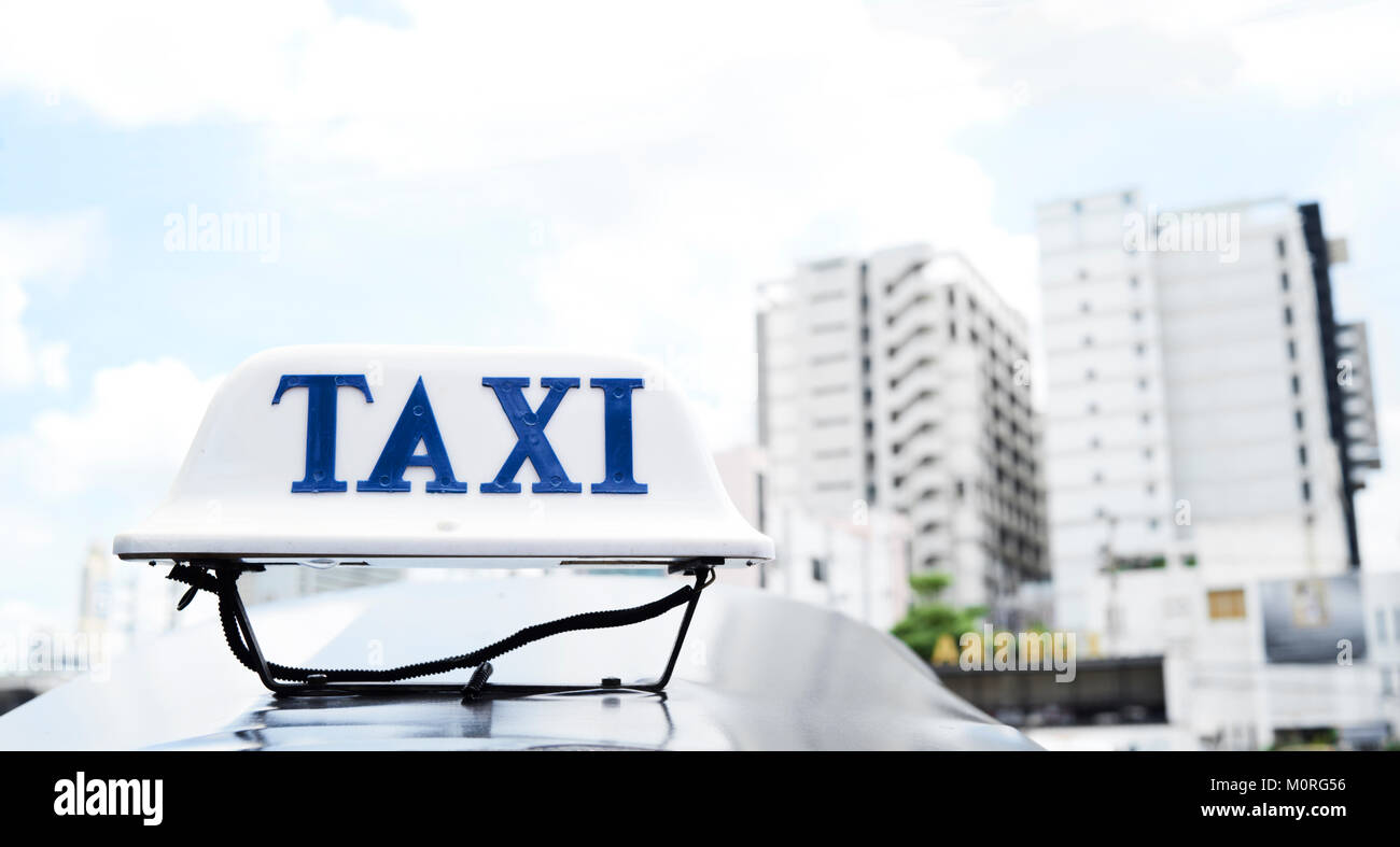 'Taxi' parola segno sulla parte superiore di un tuk-tuk veicolo a Bangkok, Thailandia, contro lo skyline della città in background. Foto Stock